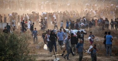 People carry relief supplies from the Gaza Humanitarian Foundation (GHF), a private U.S.-backed aid group that has bypassed the longstanding U.N.-led system in the territory, central Gaza Strip, Palestine, June 8, 2025. (AFP Photo)