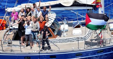 Pro-Palestine activists onboard the Madleen wave at the camera near Sicily, Italy, June 6, 2025. (AA Photo)