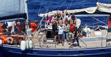 Pro-Palestine activists onboard the Madleen wave at the camera near Sicily, Italy, June 6, 2025. (AA Photo)