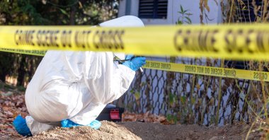 A forensic science specialist leads the identification of human remains at a crime scene investigation. (Shutterstock Photo)