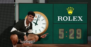 Spain&#039;s Carlos Alcaraz poses with the trophy as he points to the clock after playing the longest ever French Open men&#039;s singles final at Roland Garros, Paris, France, June 8, 2025. (Reuters Photo)