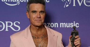 Robbie Williams poses for a portrait holding his Music Icon award at the Ivor Novello Awards, London, U.K., May 22, 2025. (Reuters Photo)
