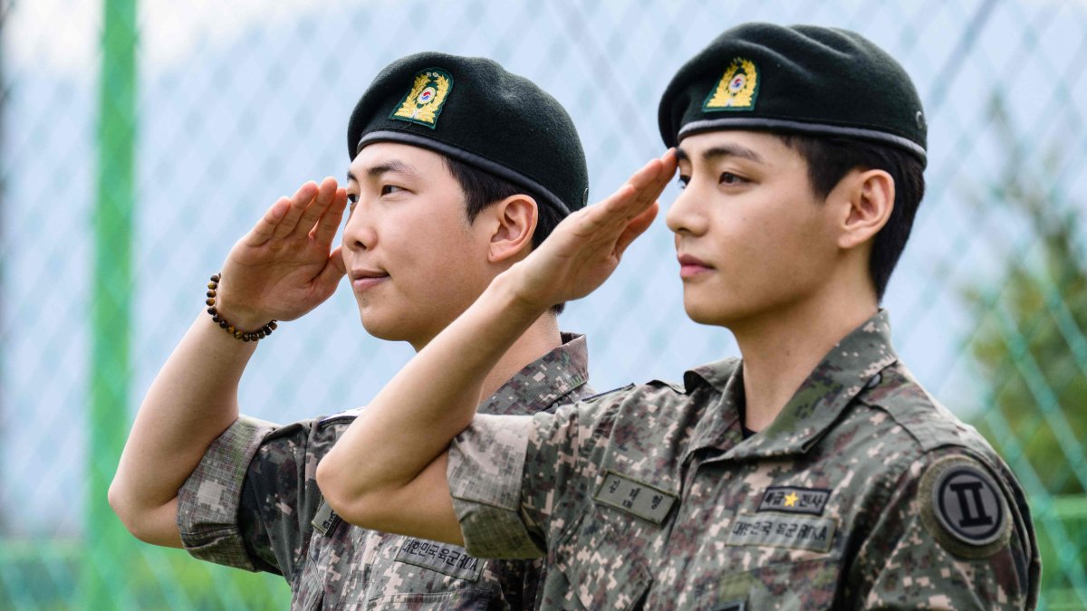 K-pop boy band BTS members RM (L) and V salute fans and members of the press at an outdoor sporting facility, Chuncheon, South Korea, June 10, 2025. (AFP Photo)