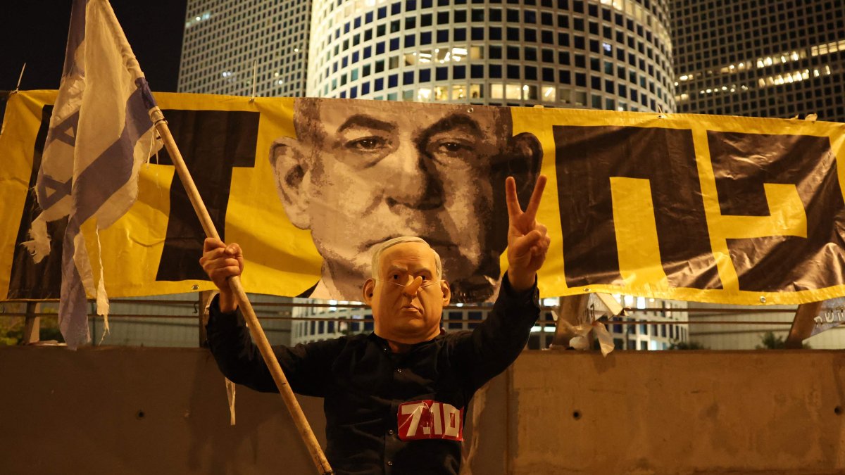 A demonstrator wearing a mask depicting Israeli Prime Minister Benjamin Netanyahu attends an anti-government protest at the Defense Ministry in Tel Aviv, June 7, 2025. (AFP Photo)