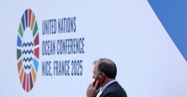 A participant makes a phone call in front of the logo of the third U.N. Ocean Conference (UNOC3), which gathers leaders, researchers and activists to discuss how to protect marine life, Nice, France, June 9, 2025. (Reuters Photo)