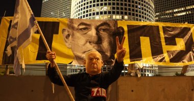 A demonstrator wearing a mask depicting Israeli Prime Minister Benjamin Netanyahu attends an anti-government protest at the Defense Ministry in Tel Aviv, June 7, 2025. (AFP Photo)