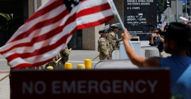 A man waves a U.S. flag as members of the California National Guard stand guard outside the Edward R. Roybal Federal building, after days of protests against federal immigration sweeps and the deployment of the California National Guard and U.S. Marines, in downtown Los Angeles, California, U.S., June 10, 2025. (Reuters Photo)