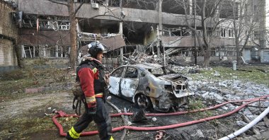 A firefighter walks past a burnt car following a Russian drone strike, Kharkiv, Ukraine, June 11, 2025. (AFP Photo)