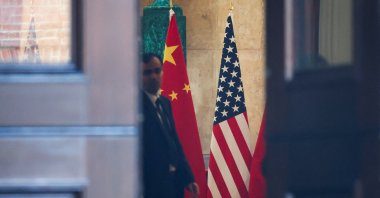 A man stands next to U.S. and China flags at Lancaster House, on the second day scheduled for trade talks between the U.S. and China, London, Britain, June 10, 2025. (Reuters Photo)