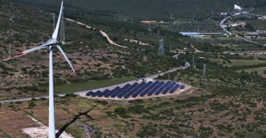 A wind turbine and solar panels seen in the Aegean province of Izmir, Türkiye, May 8, 2025. (AA Photo)
