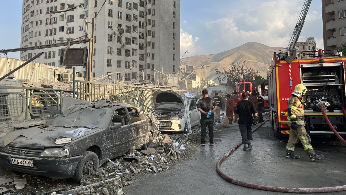 Fire fighters work outside a building that was hit by Israeli air strikes north of Tehran, Iran, June 13, 2025. (EPA Photo)
