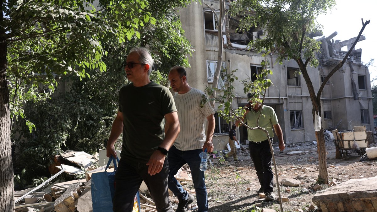 People walk past a damaged building, in the aftermath of Israeli strikes, in Tehran, Iran, June 13, 2025. (Reuters Photo)