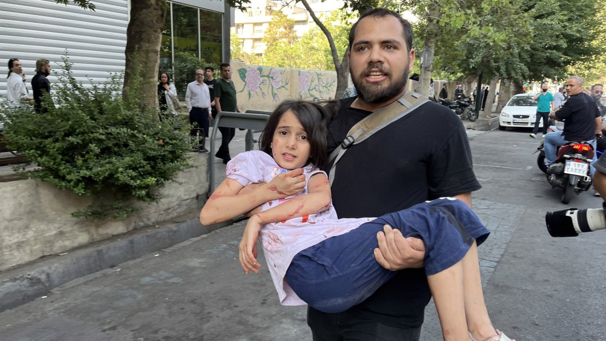 A man carries his wounded child following an Israeli airstrike in central Tehran, Iran, June 15, 2025. (EPA Photo)