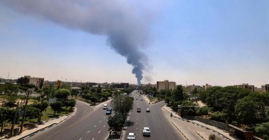 Commuters drive along a road as a plume of heavy smoke and fire rises from an oil refinery in southern Tehran, Iran, June 15, 2025. (AFP Photo)