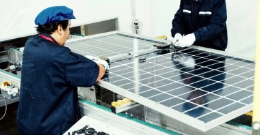 Workers are seen preparing a solar panel in this undated photo. (Shutterstock Photo)