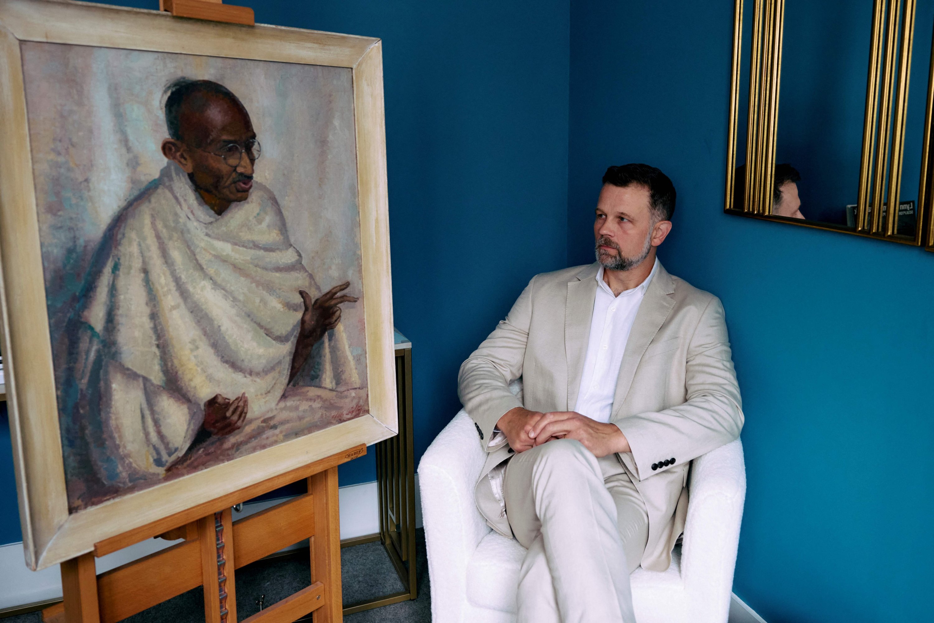 Caspar Leighton, great-nephew of British-American artist Clare Leighton, poses with a painting by his great-aunt of Indian independence leader Mahatma Gandhi at Bonhams auction house, London, U.K., June 9, 2025. (AFP Photo)