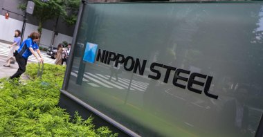 People walk past signage showing the logo of Japan&#039;s largest steel manufacturer, Nippon Steel, in front of the company&#039;s head offices in central Tokyo, Japan, June 16, 2025. (AFP Photo)