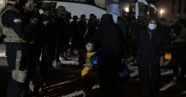 Soldiers stand guard as Syrian families evacuate al-Hol camp in northeastern Syria, June 16, 2025. (AA Photo)