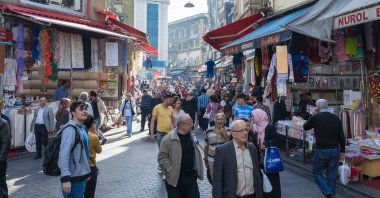 A bustling marketplace is filled with people exploring textile shops, street vendors and small businesses, Istanbul, Türkiye. (Shutterstock Photo)