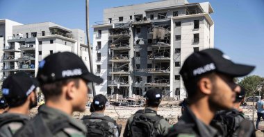 Members of Israeli security forces check the destruction in front of a residential building hit during an Iranian missile attack, Beersheba, southern Israel, June 20, 2025. (AFP Photo)