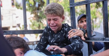 Boys mourn by the body of a Palestinian man who was killed a day earlier in Israeli fire while seeking food aid, during his funeral at Al-Shifa hospital, Gaza City, Palestine, June 18, 2025. (AFP Photo)