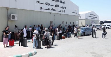 Expats, including diplomats from different nationalities, who were stranded in the occupied West Bank and Israel, wait as they hold belongings while being evacuated through the King Hussein Bridge crossing, South Shuna, Jordan, June 19, 2025. (Reuters Photo)
