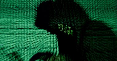 A man holds a laptop computer as cyber code is projected on him in this illustration picture created on May 13, 2017. (Reuters File Photo)