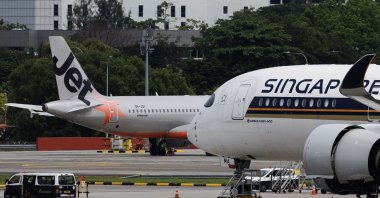 A Jetstar Asia plane (L) and a Singapore Airlines plane (R) at Changi Airport, Singapore, June 11, 2025. (EPA Photo)