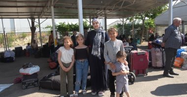 Emine Jourek Haji and her four children pose for reporters before crossing the Öncüpınar border to Syria, in southeastern Kilis province, Türkiye, June 23, 2025. (IHA Photo)