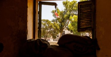 The flags of Türkiye and TRNC are being seen through a window of an abandoned house, Lefkoşa (Nicosia), island of Cyprus, July 20, 2024. (Getty Images Photo)