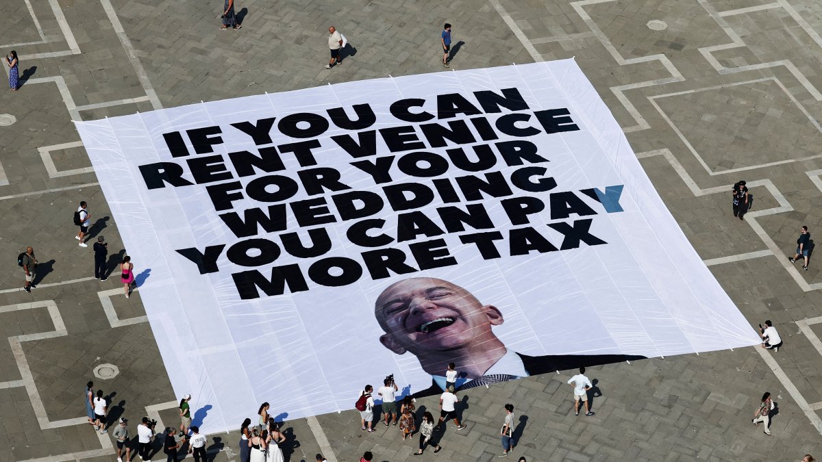 A large banner against Amazon founder Jeff Bezos lies on the ground, placed by Greenpeace Italy activists and U.K. activist group &quot;Everyone Hates Elon,&quot; St. Mark&#039;s Square, Venice, Italy, June 23, 2025. (Reuters Photo)