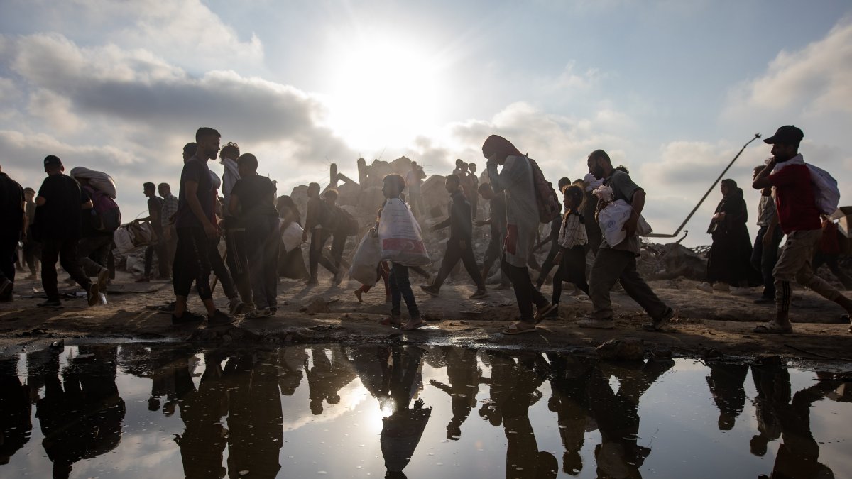 Displaced Palestinians carry relief packages along Rashid Street, west of Jabalia, Gaza, Palestine, June 22, 2025. (EPA Photo)