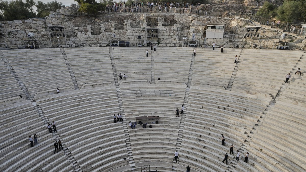 Tourists watch the ushers as they prepare the Odeon of Herodes Atticus ahead of the dress rehearsal of Giacomo Puccini&#039;s &quot;Turandot&quot; by the Greek National Opera during the 70th Athens Epidaurus Festival, Athens, Greece, May 30, 2025. (AP Photo)