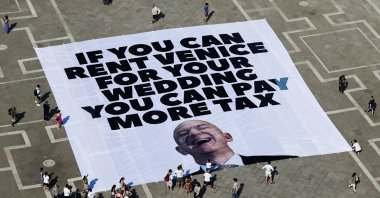 A large banner against Amazon founder Jeff Bezos lies on the ground, placed by Greenpeace Italy activists and U.K. activist group &quot;Everyone Hates Elon,&quot; St. Mark&#039;s Square, Venice, Italy, June 23, 2025. (Reuters Photo)