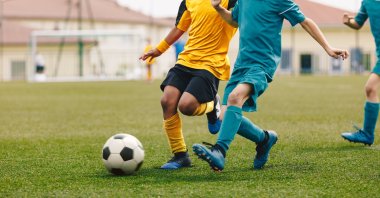 Young boys play football at a stadium during a sports event. (Shutterstock Photo) 