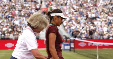 Britain's Emma Raducanu receives medical attention after sustaining an injury during her Queen's Club Championships quarterfinal match against China's Qinwen Zheng at the Queen's Club, London, U.K., June 13, 2025. (Reuters Photo)