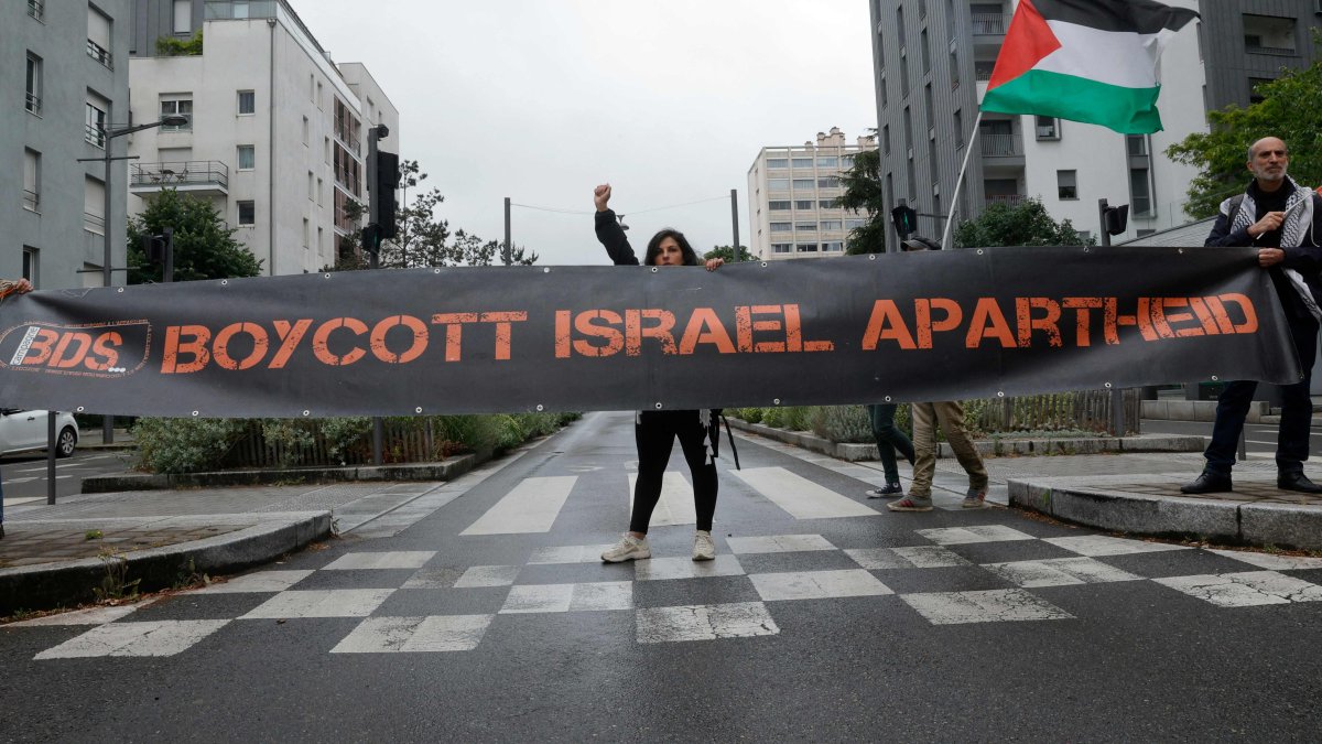 Activists from Boycott, Divestment and Sanctions (BDS) hold a banner and a Palestinian flag during anti-Israel protests, in Massy, near Paris, France, May 28, 2025. (AFP Photo)