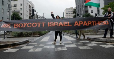 Activists from Boycott, Divestment and Sanctions (BDS) hold a banner and a Palestinian flag during anti-Israel protests, in Massy, near Paris, France, May 28, 2025. (AFP Photo)