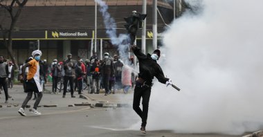 A demonstrator throws back a teargas canister shot by police during a protest in the central business district in Nairobi, Kenya, 25 June 2025. (EPA Photo)