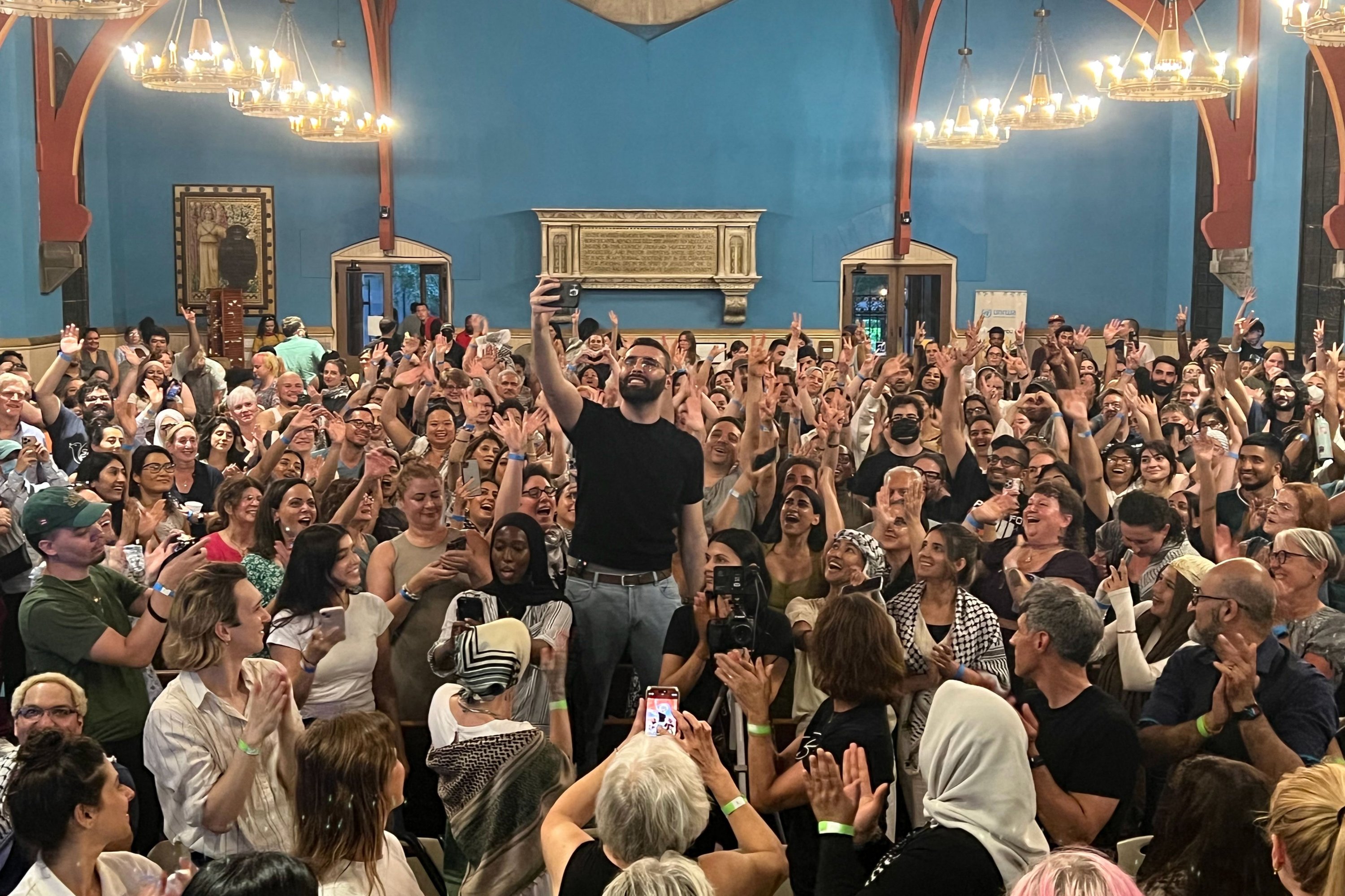 Palestinian photographer and Instagram star Motaz Azaiza stands in the middle of the crowd during an event at the First Unitarian Church of Philadelphia to collect donations for the UNRWA, Philadelphia, Pennsylvania, U.S., June 23, 2025. (AFP Photo)