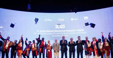Culture and Tourism Minister Mehmet Nuri Ersoy and YTB President Abdullah Eren pose with students after the cap toss at the 14th International Students Graduation Ceremony, Ankara, Türkiye, June 25, 2025. (AA Photo)