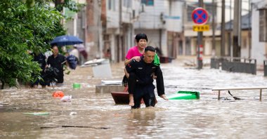 A rescuer helps evacuate a senior resident from a flood-affected area in Congjiang County, Guizhou Province, China, June 24, 2025. (EPA Photo)