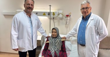 Güler Turan poses with doctors after a 10-hour surgery that replaced her blocked main coronary artery and three heart valves in Izmir, Türkiye, June 27, 2025. (AA Photo)