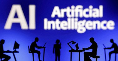 Figurines with computers and smartphones seen in front of the words &quot;Artificial Intelligence AI&quot; in this illustration taken, Feb. 19, 2024. (Reuters Photo)