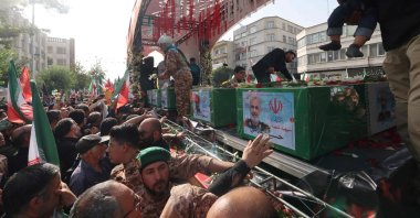 A mourner reaches out to touch the coffin of Iranian Revolutionary Guards commander Hossein Salami (C), and other military commanders killed during Israeli strikes on Iran, during their funeral procession at Enghelab (Revolution) Square in the capital Tehran, Iran, June 28, 2025. (AFP Photo)