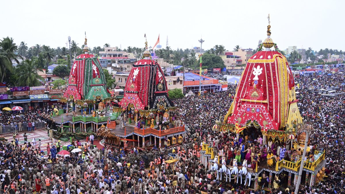 Hindu devotees walk in a procession accompanying three large chariots housing deities, in Puri, India, June 28, 2025. (AP Photo)