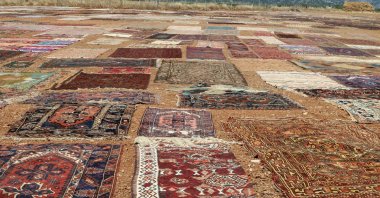 Rows of handwoven carpets dry and fade under the intense summer sun, Antalya, Türkiye, June 29, 2025. (DHA Photo)