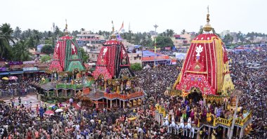 Hindu devotees walk in a procession accompanying three large chariots housing deities, in Puri, India, June 28, 2025. (AP Photo)