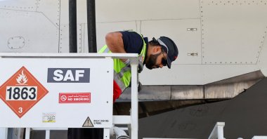 A staff member is pictured as he fills up the Emirates Airlines Boeing 777-300ER with Sustainable Aviation Fuel (SAF), during a milestone demonstration flight while running one of its engines on 100% (SAF), Dubai, United Arab Emirates (UAE), Jan. 30, 2023. (Reuters Photo)