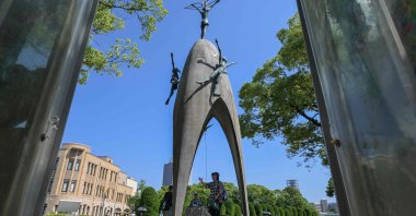 A visitor (C) rings the bell at the Children&#039;s Peace Monument inside the Peace Memorial Park, in the center of Hiroshima, Hiroshima Prefecture, Japan, June 28, 2025. (AFP Photo)